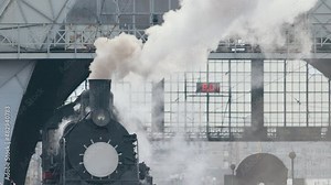Vintage black steam locomotive. Historic train runs through fields. Vehicle