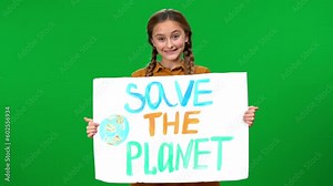 Girl opening Save the planet banner smiling looking at camera standing at chroma key background. Portrait of caring Caucasian teenager advertising environmental protection on green screen