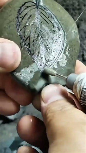 carving intricate patterns on a natural stone surface using a high speed rotary power tool craft