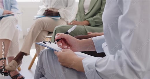 Woman writing notes during meeting in women group. Hands of girl sitting on chair with pen and clipboard to listen, record important points at corporate workshop, teamwork training session in office