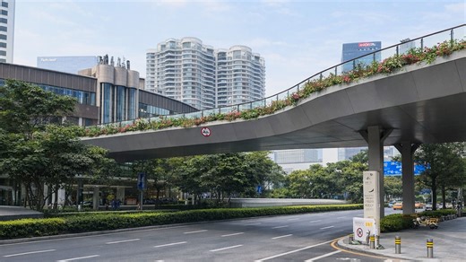A curved bridge in China directs movement between city spaces above road