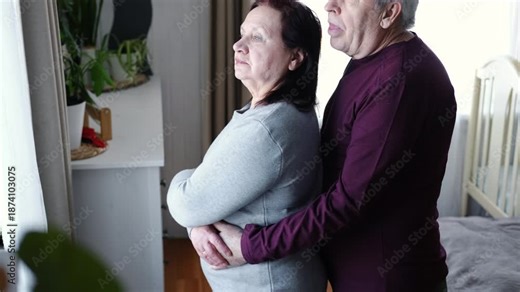Senior couple hugging each other, kissing at home bedroom. Intimate Moment. Tender embrace between elderly age man and woman, husband and wife. Old people deep love. Time and feelings. Loving family