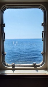 sunny blue ocean and clear sky through cruise ship window. rectangular ferry porthole with a view of the sea vertical footage