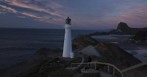 Dramatic Lighthouse on Rocky Coast at Sunrise