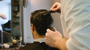 Hairdresser combing wet hair with a spray client Barbershop