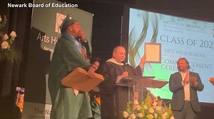 High school graduate gets job offer while walking across stage to receive diploma
