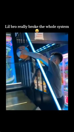ELITE BALL🥸 on Instagram: "The post shares a 21-second viral video of a young boy enthusiastically dunking a basketball on an arcade machine, causing the hoop to detach and the screen to glitch, amassing 5.3 million views since December 18, 2025. , a page focused on basketball highlights and pop culture, the clip exemplifies overzealous play breaking equipment, echoing similar incidents in arcade lore where kid strength surprises low-durability designs. User replies enhance the humor through me