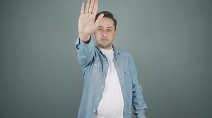 Man making stop sign for camera.