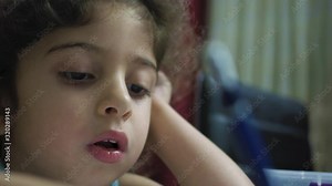 Portrait of young girl student focused on doing her homework with pencil in hand Stock Video