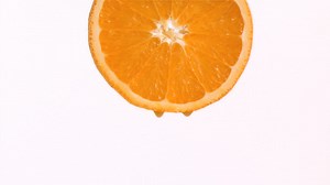 Premium stock video - Drop of orange juice in super slow motion falling