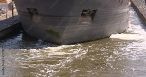 Inland ship using its maneuvering thruster in a lock pound. Note the transversal water jet. Stock Video