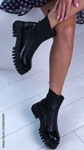 Feet of woman posing shoes. Girl fit legs in black boots. Vertical video