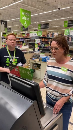 Customer Interacts with Cashier at Supermarket Self-Checkout