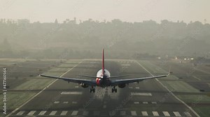 San Diego International Airport (SAN). Aircraft landing along single-runway in the foggy morning. Passenger plane flies along single runway with cloudy skies in the background. High quality 4k footage