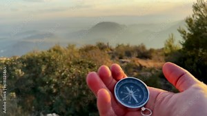 Compass in hand in mountains. Tourist compass for orientation on terrain. Magnetic declination сalculator. Map reading and land navigation concept. Orient on maps in mountains in Spain