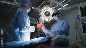 Surgeons operate patient in hospital surgery room wearing AR headsets. 3D rendering of virtual AI holographic display showing vital signs and human organs. VFX animation. Concept of modern medicine.