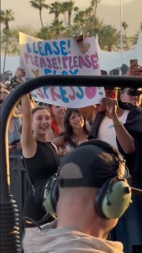 Emma Chamberlain holding a "Please play Espresso" sign during Sabrina Carpenter's Coachella set (W2)
