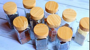 Discover array of spice jars meticulously organized for storage. Explore diverse spice containers, essential for any spice enthusiast. Perfect for showcasing kitchen organization and spice variety.