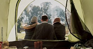 Nature group, camping tent and people relax, bond and enjoy scenery, morning air or rest in natural outdoor forest field. Wellness, freedom and back of camper friends on campsite, holiday or vacation