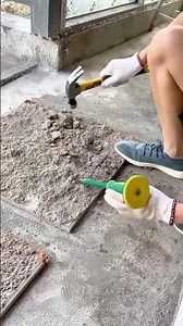 Removing old floor tiles using a chisel and hammer for surface renovation preparation