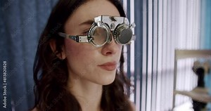 A young woman with eye equipment on during an examination in a clinic. This image captures a routine health check. Young Woman Undergoing an Eye Examination at Optometrist