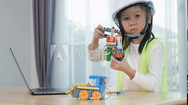 Young girl engineer working on robotics project in a STEM education class. child is focused on assembling and learning about a small robot or electronic project. engineering, innovation, technology.
