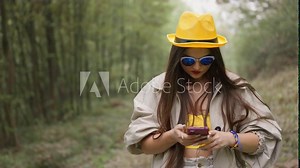 Navigation in a remote location: Railroad tracks become a guide for a traveler who uses a navigator to find her way. Crossing the forest: With a suitcase in hand, she searches for the right path with