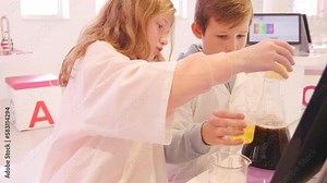 School kids in the modern educational laboratory using test tubes and reagents
