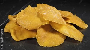 Sliced Dried Mango, Dried Fruit. Candied fruits, mango pieces. Heap of candied slices, crystallized fruit, food background.