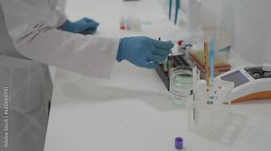 Laboratory determination of blood type. Blood test. Female laboratory assistant makes blood test, blood samples placed in cells on chart to determine the group and Rh factor. Recipient and donor.