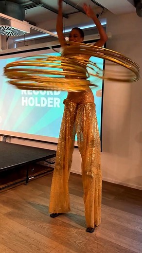Most hula hoops spun simultaneously on stilts - 27 by Amazi, aka Mariam Olayiwola 🇬🇧 | Guinness World Records