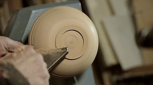 Woodturners using a rotating clamp to turn the wood.