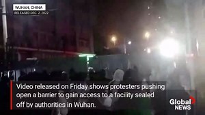 People push aside barricades in Wuhan protesting China’s strict COVID curbs