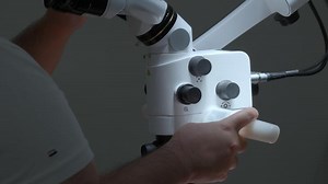 Surgeon looking into the microscope at the operating room. Action. Doctor using microscope.