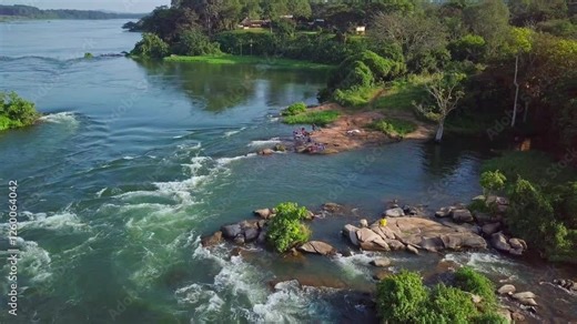 Aerial static drone shot of the River Nile in Uganda, Africa, showcasing the river's rapids, rocks, lush vegetation, and the source area of the mighty river Stock Video
