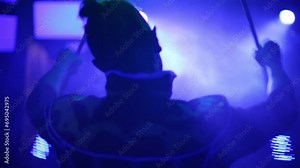 Face and back man in samurai costume performing with glow sticks