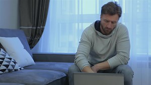 Download Man opens laptop at home for free