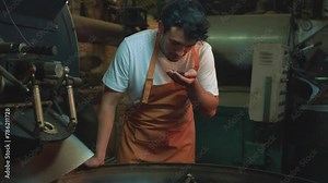 A man who is an expert in coffee evaluates freshly roasted beans, inspecting them to ensure the highest quality of the roast in an industrial setting, Small business, coffee roaster