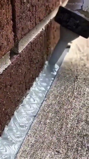 mengaplikasikan segel silikon pada celah antara dinding bata dan lantai beton lalu meratakannya