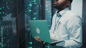 Data center. Computer security. Experienced black administrator using notebook checking working network and data server rack cabinets. Information technology.