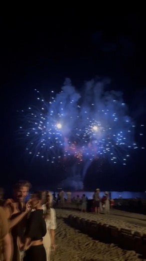 A breathtaking firework display lights up the night sky, bursting into cascades of gold, crimson, and sapphire. Each explosion blooms like a fleeting flower of light, reflecting softly in the darkness below 🎆✨