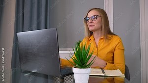 Happy young woman freelancer work on computer typing text messages from home, . she finishes work, leans back on couch and throws her hands behind her head.. Job done. end of day