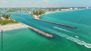 Sea shore inlet with white yachts sailing on colorful waves. North and South Jetty on Nokomis beach near Venice, Florida. Motorboat recreation on ocean surface