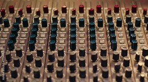 Music recording studio control room with pre amp knobs used for volume level adjustments. Stereo equipment as equalizer, mixer, switchers and sliders are operated in post production.