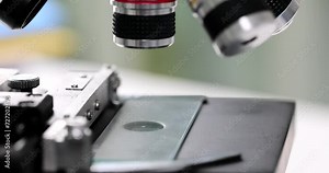Research microscope with glass in laboratory closeup. Laboratory and binocular microscopes and magnified specimen images
