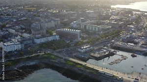 Lexicon, Dún Laoghaire, Dublin, Ireland, August 2021. Drone slowly orbits modern library building surrounded by coastal town.