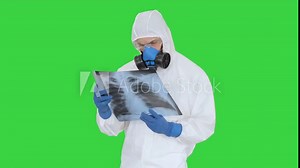 Medical doctor in protective suit walking in with x-ray picture on a Green Screen, Chroma Key.