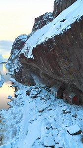Two tiny houses tucked beneath a towering cliff, where people once lived sheltered by nature itself. A powerful reminder of how harsh landscapes shaped resilient lives along Norway’s coast. 🤩🇳🇴 | Spectacular Norway