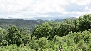 Evergreen landscape with hills, pine forests in the distance and mountains pro sided over by clouds. Stock Video