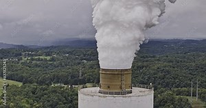Brilliant Ohio Aerial v5 zoomed drone fly around power plant capturing flue-gas stack emitting white smokes into the air against hills and river landscape - Shot with Mavic 3 Pro Cine - September 2023